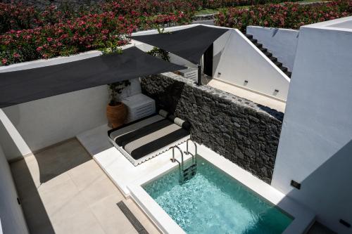 an overhead view of a swimming pool with an umbrella at Cresanto Luxury Suites in Imerovigli