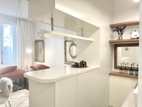 a kitchen with white cabinets and a mirror at Studio climatisé pour 1 ou 2 personnes au 109 avenue Mozart Paris 16 in Paris