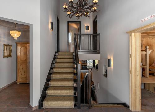 a staircase in a home with a chandelier at Chalet Avidea Secret in Avelengo