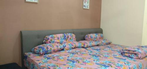 a bed with colorful sheets and pillows in a bedroom at Jeli Heights Hill Homes in Jeli