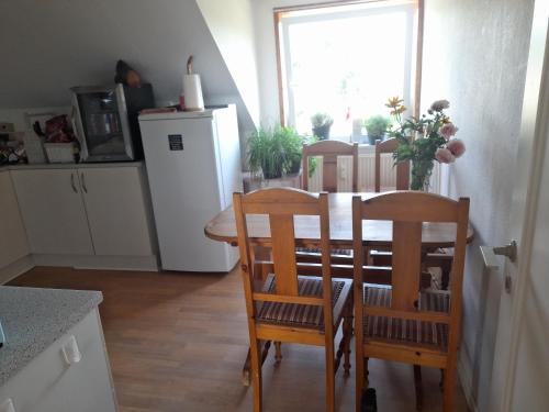 a kitchen with a table and chairs and a refrigerator at Holiday apartment & boat rental in Sindal