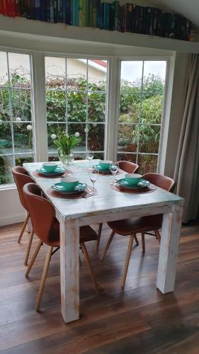 a wooden table with chairs and a table with wine glasses at dutchduochalet13 in 's-Gravenzande