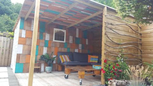 a wooden pergola with a couch on a patio at dutchduochalet13 in 's-Gravenzande