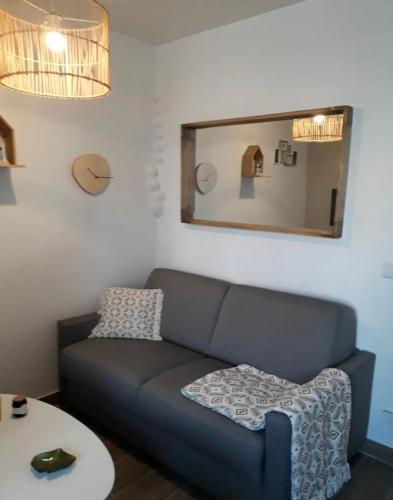 un salon avec un canapé et un miroir dans l'établissement Appartement Vacances, à Laval