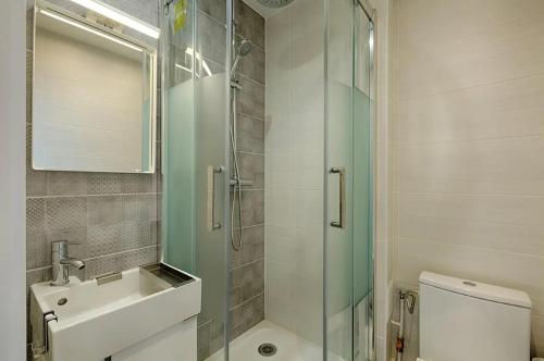 une salle de bain avec une douche, un lavabo et des toilettes dans l'établissement Appartement Vacances, à Laval