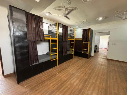 Habitación con 3 literas y suelo de madera. en Dorm Hub, en Dehradun