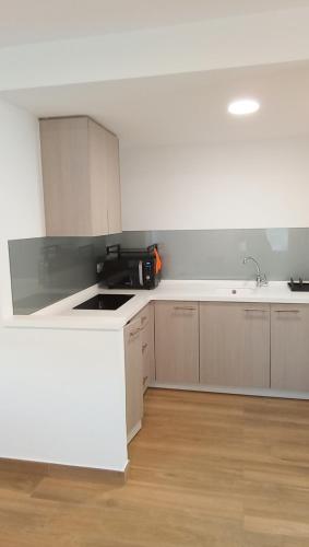 a white kitchen with a sink and a counter at Mar de Queiruga: 02 Xeiteira in Porto do Son