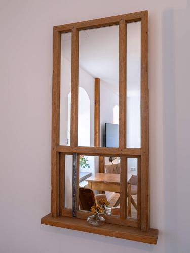 a mirror with a wooden frame hanging on a wall at Lindenhof Michaelis - Urlaub auf dem historischen Gutshof in Liebstadt