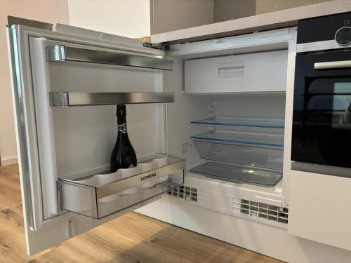 an open refrigerator with a bottle of wine in it at Lindenhof Michaelis - Urlaub auf dem historischen Gutshof in Liebstadt