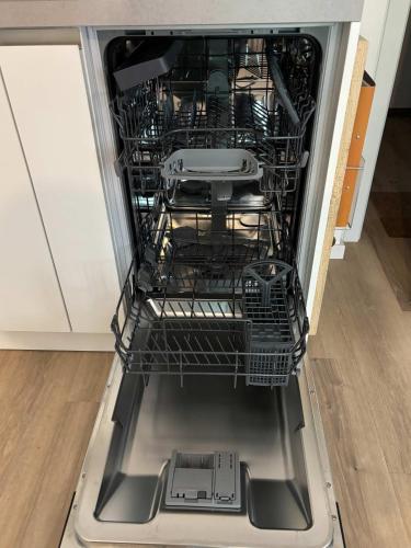 an open dishwasher with dishes inside of it at Lindenhof Michaelis - Urlaub auf dem historischen Gutshof in Liebstadt