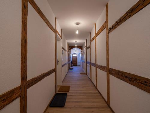a corridor of a hallway with wooden floors and walls at Lindenhof Michaelis - Urlaub auf dem historischen Gutshof in Liebstadt