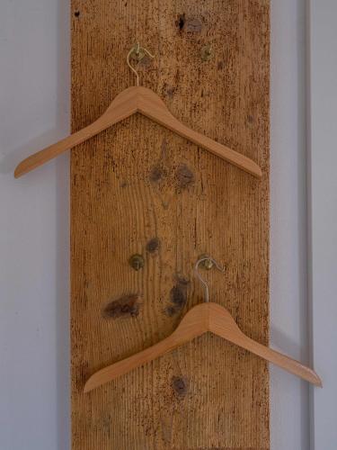 two wooden hangers on a wooden wall with fingerprints at Lindenhof Michaelis - Urlaub auf dem historischen Gutshof in Liebstadt