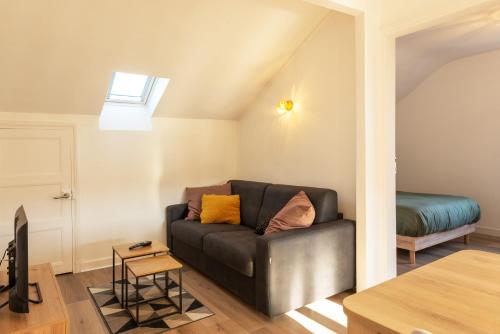 un salon avec un canapé et un lit dans l'établissement Appartement Moderne, Confortable et Bien Situé, à Aurillac