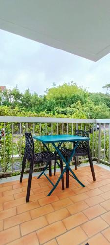 une table bleue sur le balcon d'une maison dans l'établissement charmant studio plage et marché à pied, à Pornichet