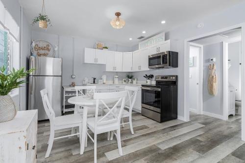 a kitchen with white appliances and a table and chairs at Dune Our Thing - Building A - 171 Washington condo in Fort Myers Beach