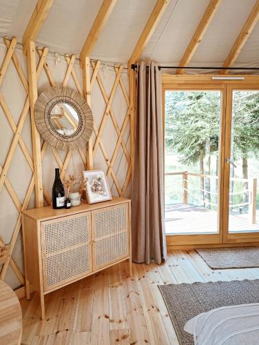 a room with a mirror and a bed and a window at Jurta w Dolinie Sanu in Krzemienna