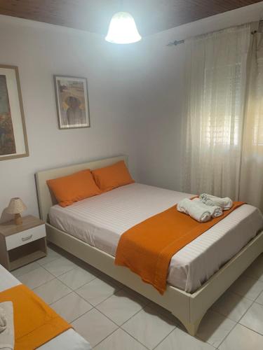 a bedroom with two beds with orange and white at Anastelia Apartments - The Backyard in Olympiada