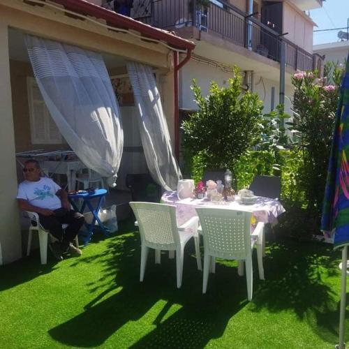 a table and chairs in the yard of a house at Anastelia Apartments - The Backyard in Olympiada