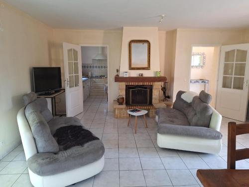 a living room with two couches and a fireplace at Gîte du Couchant à Fleurance dans le Gers en occitanie in Fleurance