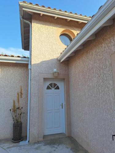 a house with a white door and a window at Gîte du Couchant à Fleurance dans le Gers en occitanie in Fleurance