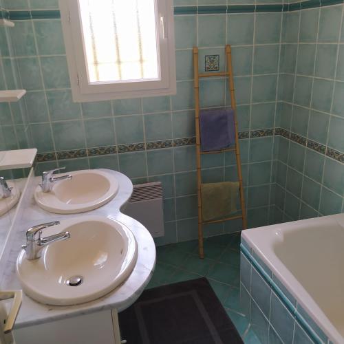 a bathroom with two sinks and a bath tub at Gîte du Couchant à Fleurance dans le Gers en occitanie in Fleurance
