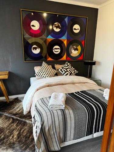 a bedroom with a bed with records on the wall at comfortavel in Figueira da Foz