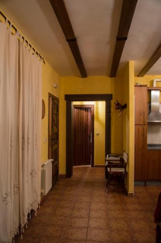 a hallway of a house with yellow walls and a door at Apartamentos Rurales Alvado in Tamajón