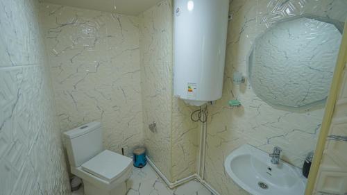 a bathroom with a toilet and a sink at Givi Kakhiani's Svaneti Guesthouse in Zhabeshi