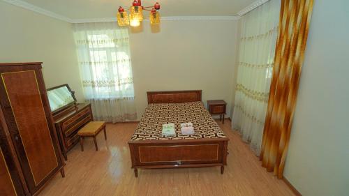 a room with a bed and a table and a piano at Givi Kakhiani's Svaneti Guesthouse in Zhabeshi