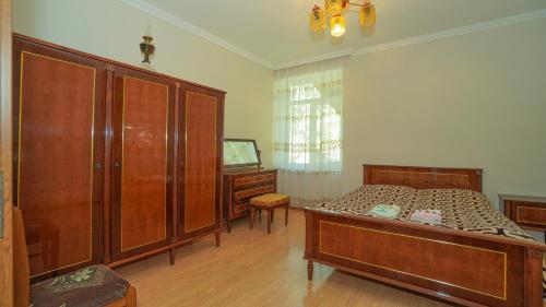 a bedroom with a bed and some wooden cabinets at Givi Kakhiani's Svaneti Guesthouse in Zhabeshi
