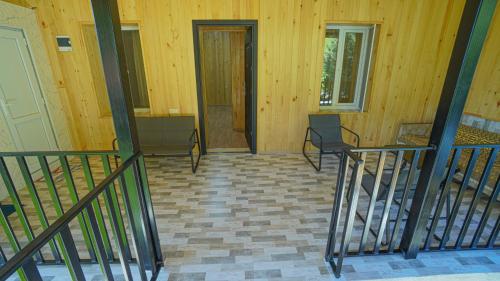 a room with a staircase and a door with chairs at Givi Kakhiani's Svaneti Guesthouse in Zhabeshi