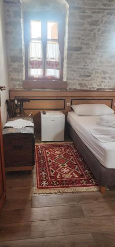 a bedroom with a bed and a rug on the floor at Silver Hill Guesthouse in Gjirokastër