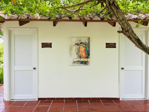 a painting on the wall of a house with two doors at Hotel Carey Beach Baru in Baru