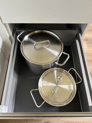 two pots on a stove top in a drawer at Lindenhof Michaelis - Urlaub auf dem historischen Gutshof in Liebstadt