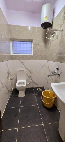 a bathroom with a toilet and a sink at Nandan Residency in Mysore