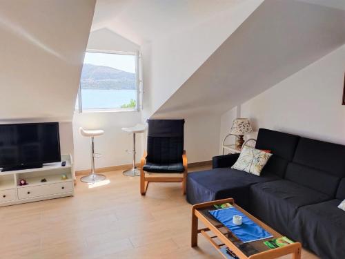 un salon avec un canapé et une télévision dans l'établissement Ático Agarimos do Mar, à Corcubión