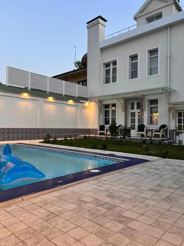 a house with a swimming pool in front of a house at Anor in Tashkent