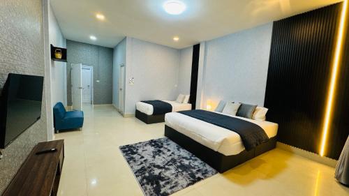 a hotel room with two beds and a bathroom at Vela House Hatyai in Hat Yai