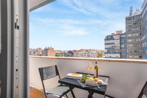 a balcony with a table and chairs and a window at Modern Apartment by CM Properties in Amadora