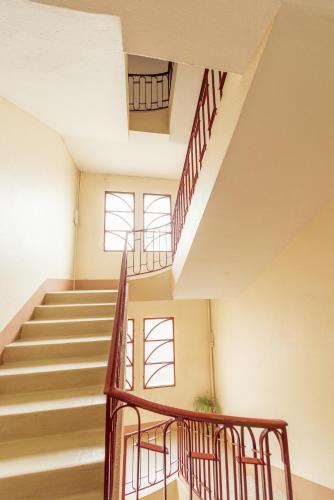 - un escalier dans un bâtiment avec deux fenêtres dans l'établissement Grand Appartement Lumineux au Centre d'Aurillac, à Aurillac