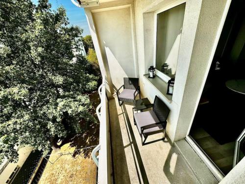 an overhead view of a balcony with two chairs and a window at KMHosting Zentrum Luxe Apartment Balkon in Chemnitz