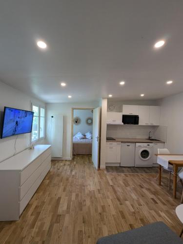 une grande cuisine avec des armoires blanches et une table dans l'établissement Petite maison indépendante, à Livry-Gargan