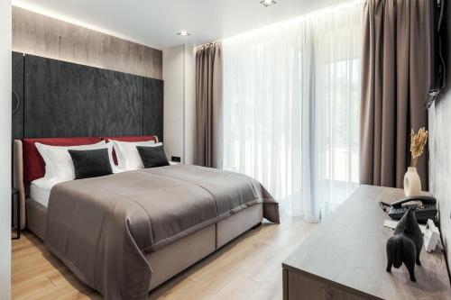a bedroom with a bed and a large window at Glacier Premium Apartments in Bukovel