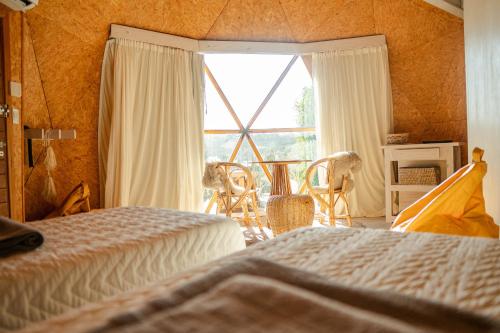a bedroom with two beds and a large window at Domo 2 - Domos Aiken Chapa Glamping en Zona Cruz del Sur Chapadmalal para 2 PAX - Hola Sur in Mar del Plata