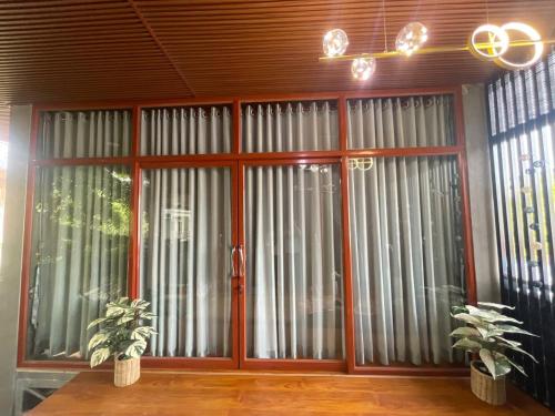 a large glass door with two plants in front of it at Mother’s House in Battambang
