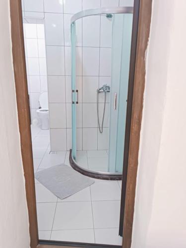 a shower with a glass door in a bathroom at Kalipso motel in Çeşme