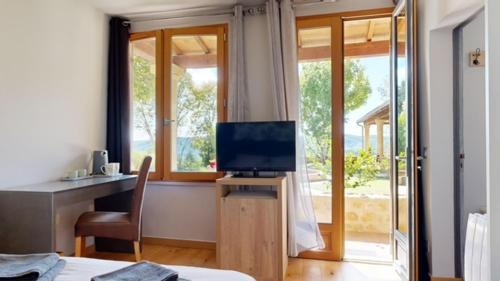 Una televisión o centro de entretenimiento en Domaine de la source périgordnoir Chambre d'hôtes LA FONTAINE