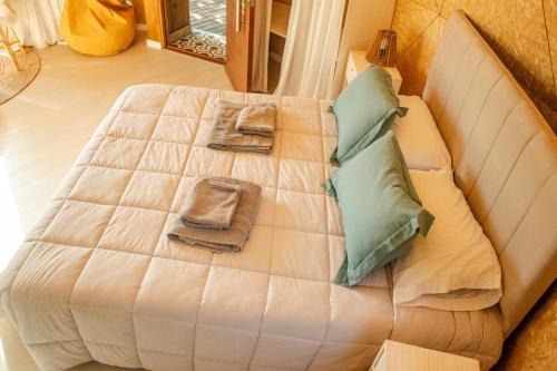une chambre avec un grand lit blanc avec des oreillers dans l'établissement Domo 3 - Domos Aiken Chapa Glamping en Zona Cruz del Sur Chapadmalal para 2 PAX - Hola Sur, à Mar del Plata
