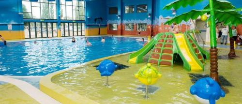 a pool with a slide in a swimming pool at Beautiful 2 bedroom caravan on Billing Aquadrome in Northampton