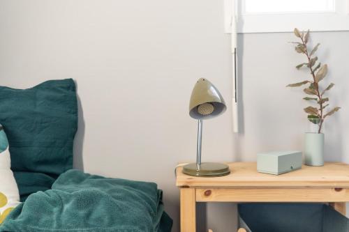 a table with a lamp on it next to a bed at Horizon Feng Shui - jardin, terrasse et vue in Ceyrat